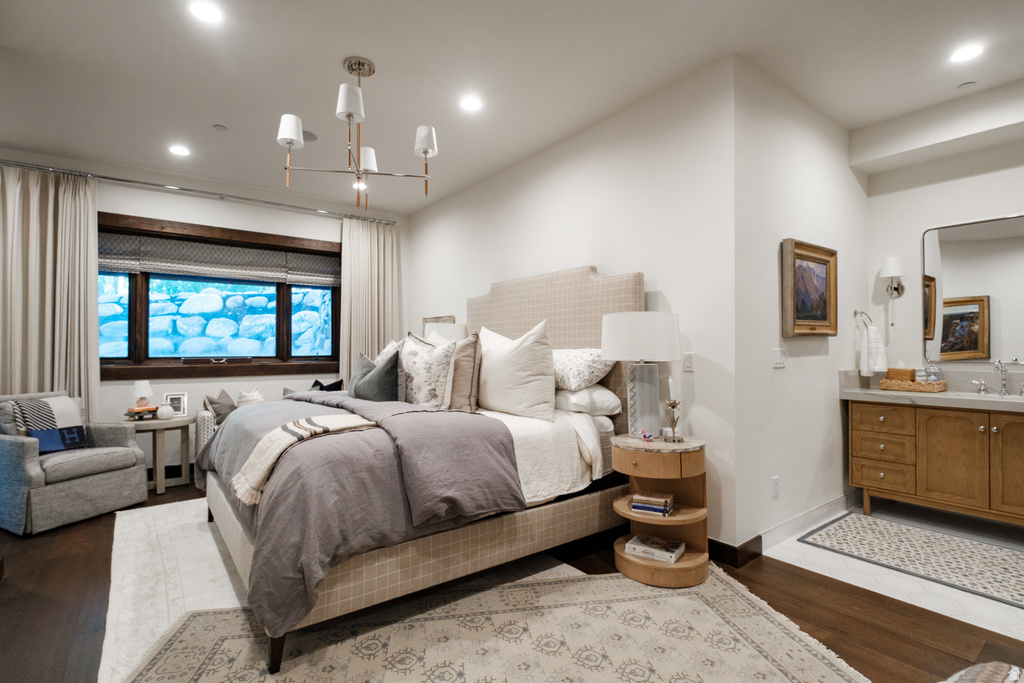 Bedroom featuring recessed lighting, dark wood-finish flooring, and a large window with wood trim