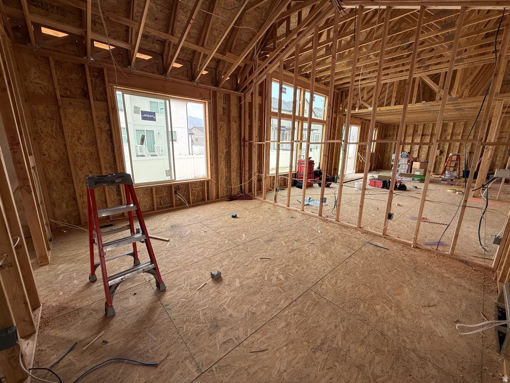 Framed interior space featuring structural wood framing, oriented strand board subflooring, and multiple window openings
