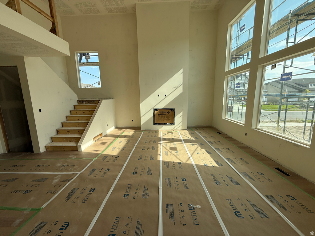 Great room with a two-story ceiling, a built-in fireplace, and large multi-pane windows