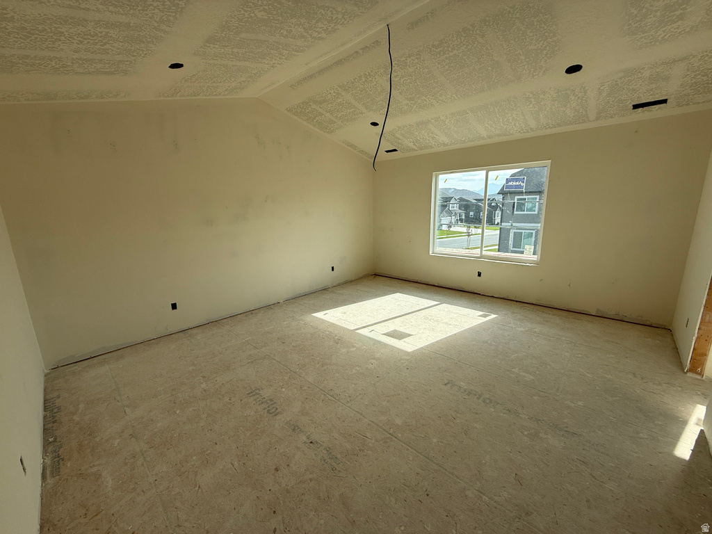 Vaulted ceiling, recessed lighting, and a large window