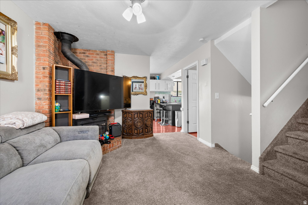 Living area with wall-mounted television over a brick-faced fireplace, featuring a built-in shelf