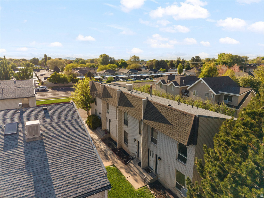 Row of attached townhome-style residences featuring light-colored brick facades and dark shingle roofs