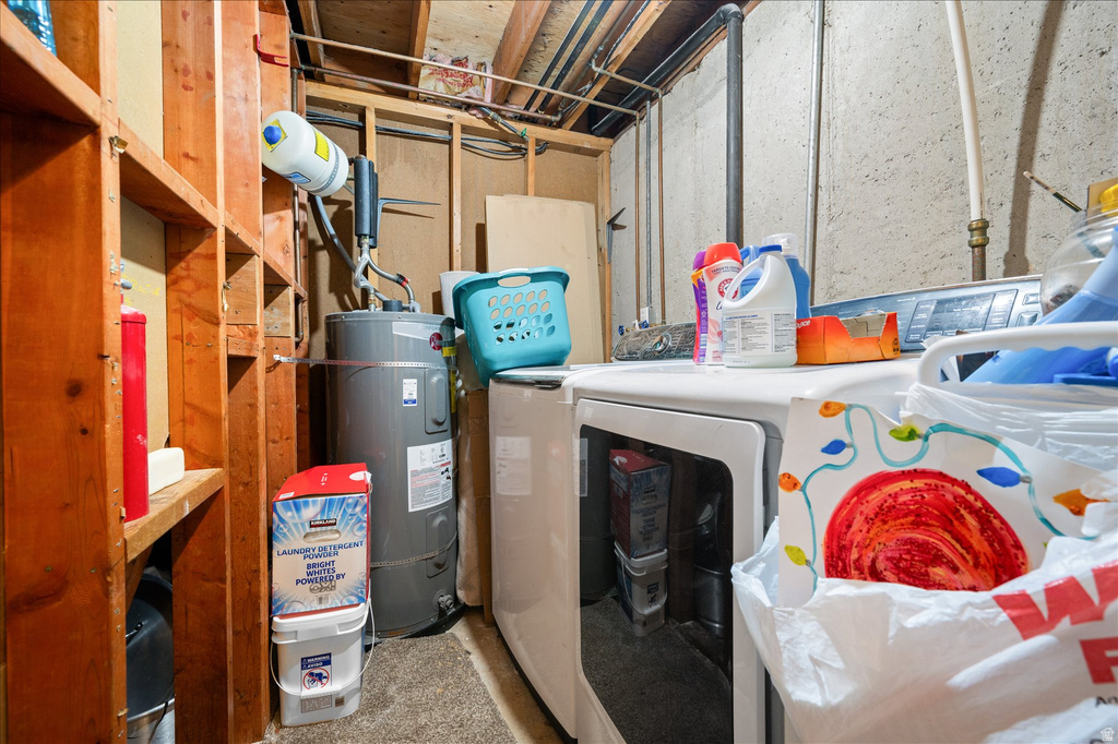 Utility area featuring a water heater, laundry appliances, and exposed wood framing