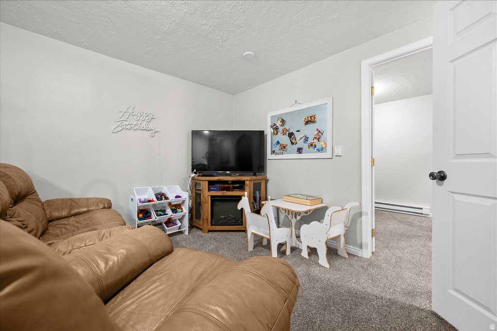 Carpeted room with light gray walls, featuring a built-in electric fireplace within a wood-finish media console