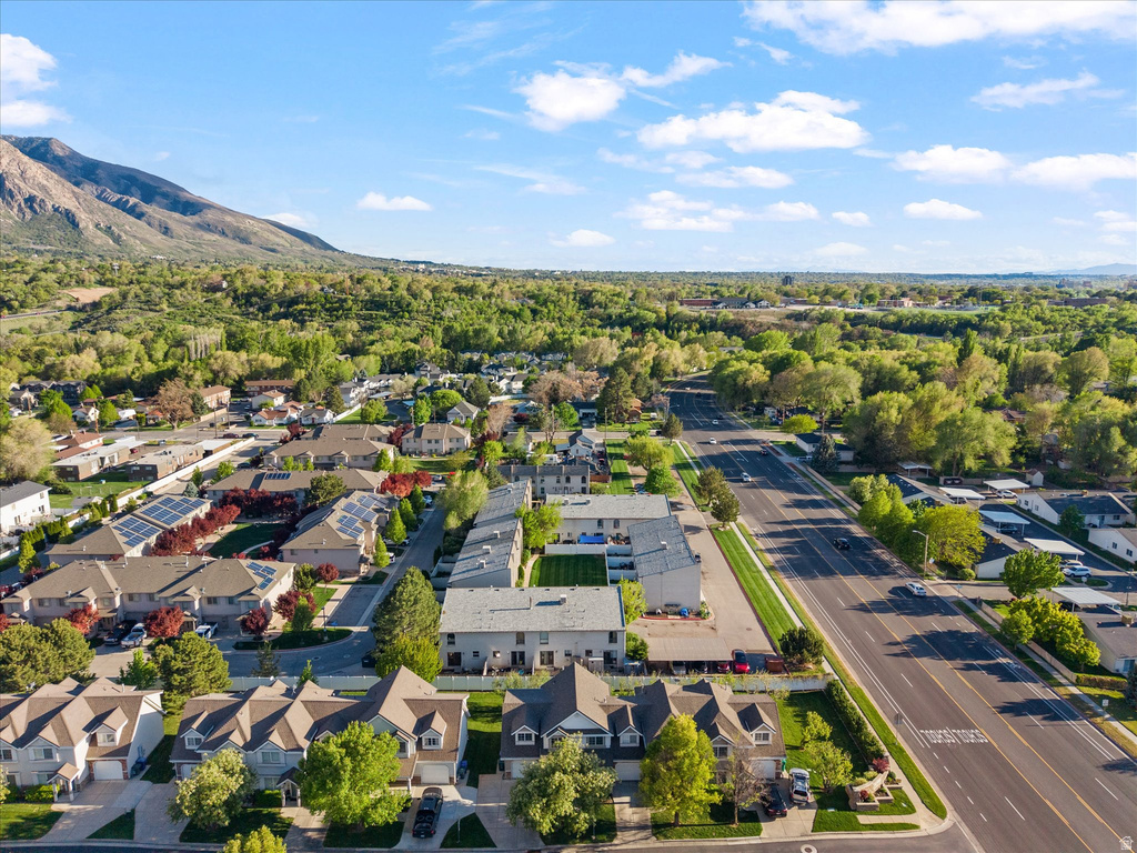 Residential community featuring a variety of architectural styles, mature trees, mountain scenery, and solar panels visible on several rooftops