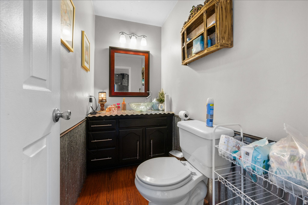 Bathroom with dark wood-finish vanity, vessel sink, and wood-finish flooring