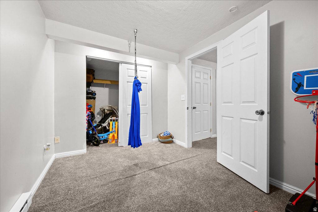 Carpeted room featuring a white paneled door, sliding closet doors, and recessed lighting