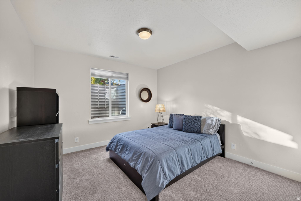 Light gray wall color, neutral carpeting, and a single window with white trim
