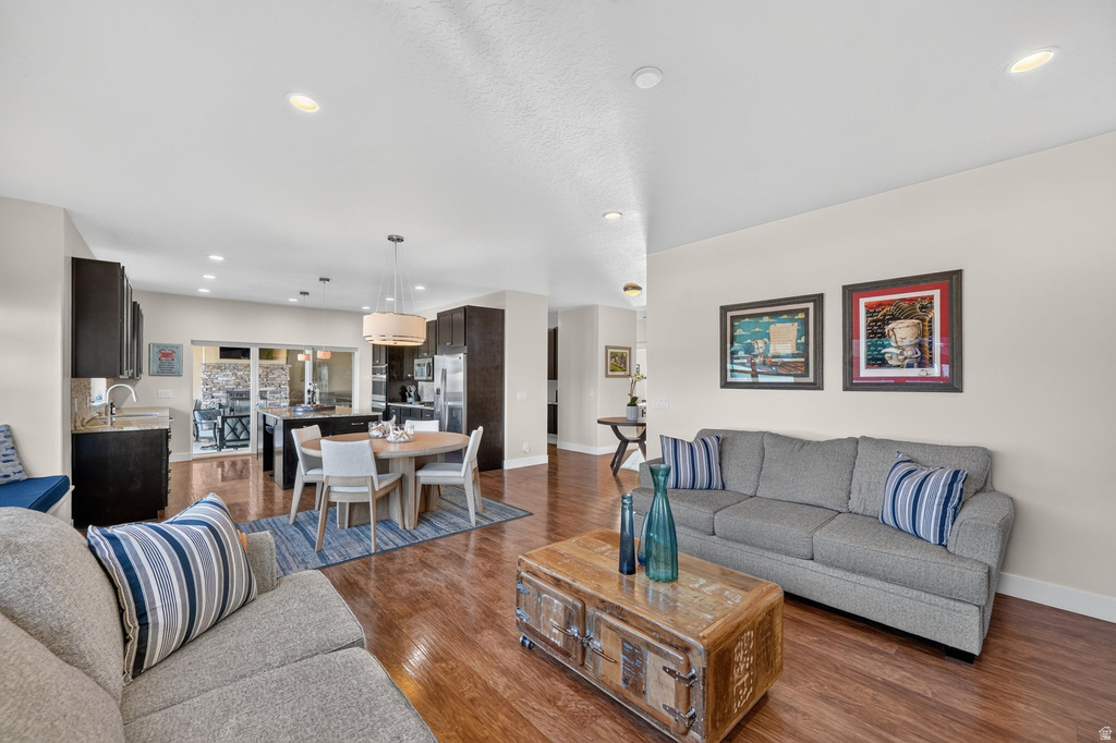 Open-concept living space featuring wood-finish flooring, recessed lighting, and light-toned walls