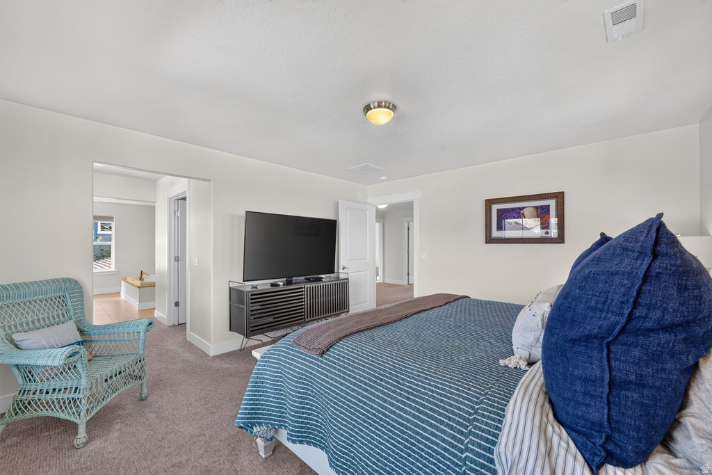 Carpeted bedroom featuring neutral wall finishes and a built-in ceiling light fixture