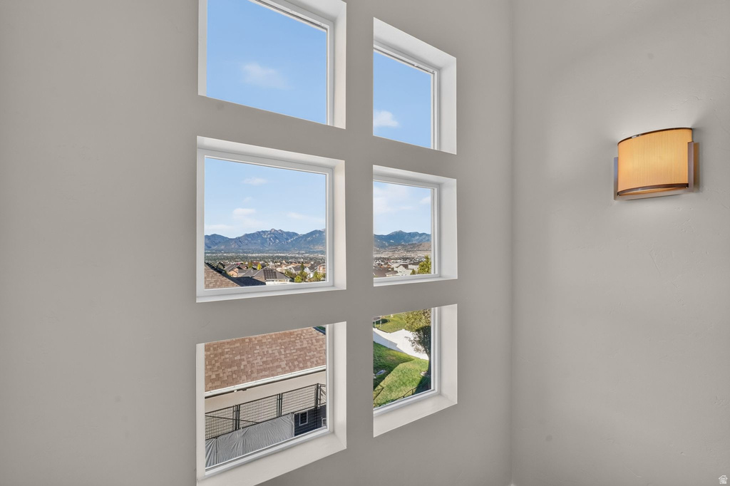 Multi-pane window array with a mountain backdrop, complemented by an elegant wall sconce