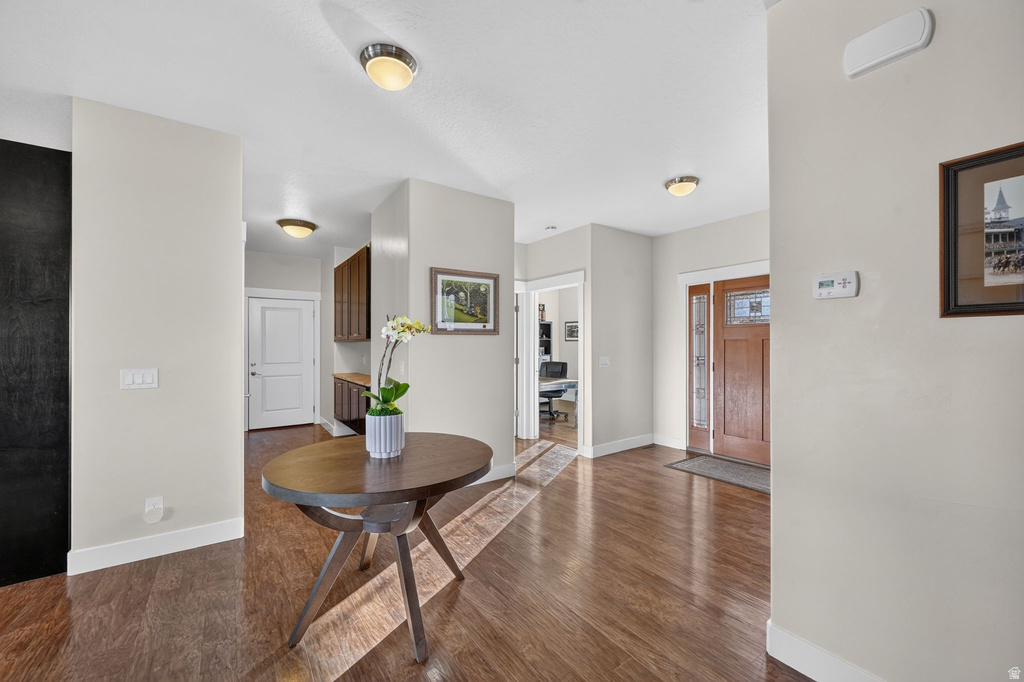 Entryway featuring rich wood-finish flooring, a solid wood front door with decorative glass inserts, and recessed lighting