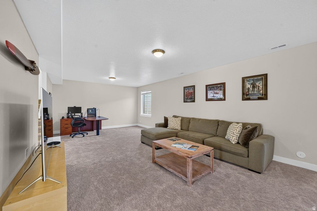 Spacious room featuring neutral carpeting, light-toned walls, and recessed lighting