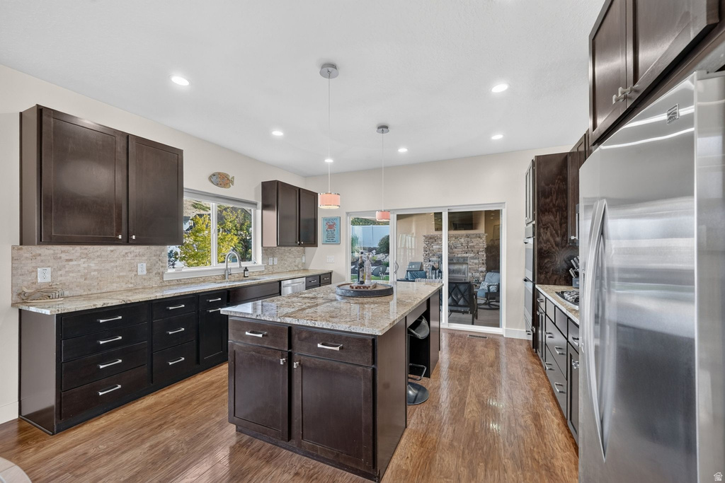 Expansive kitchen featuring dark wood-finish cabinetry, light-toned countertops, and wood-finish flooring