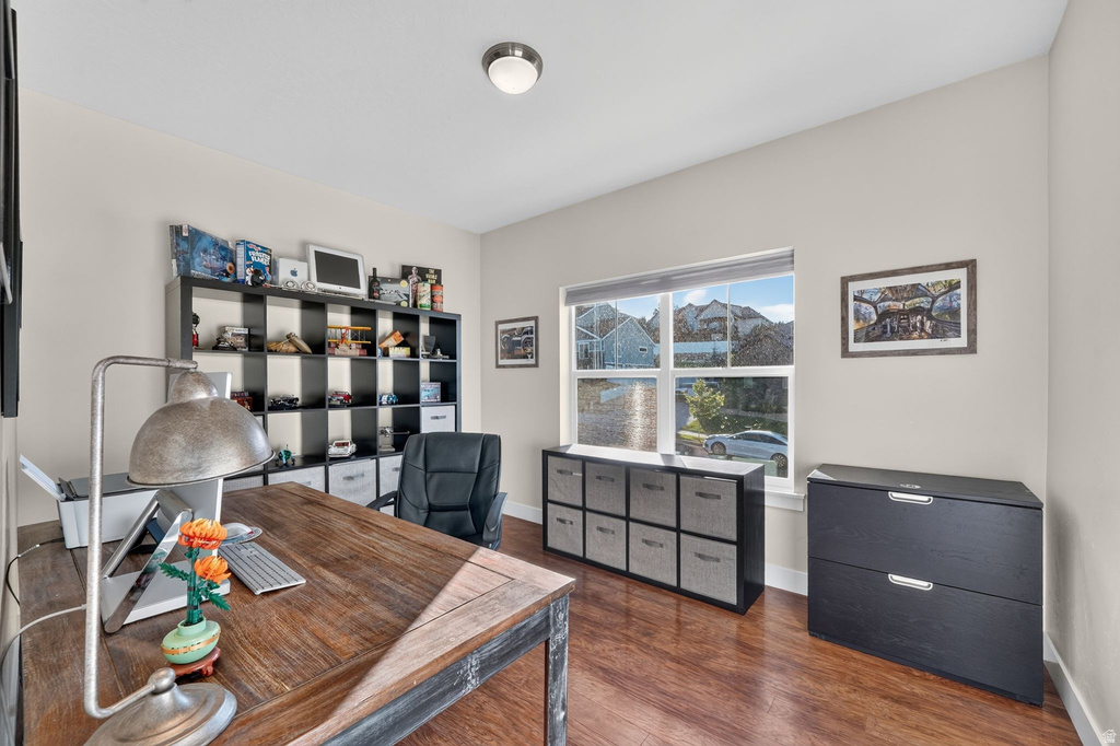 Versatile room featuring wood-finish flooring, neutral wall tones, a large window, and a flush mount ceiling light