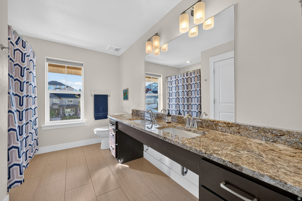 Double vanity featuring a light-toned countertop, two integrated sinks, and individual faucets