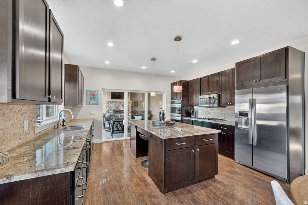 Kitchen featuring wood-finish flooring, dark wood cabinetry, and light-toned countertops