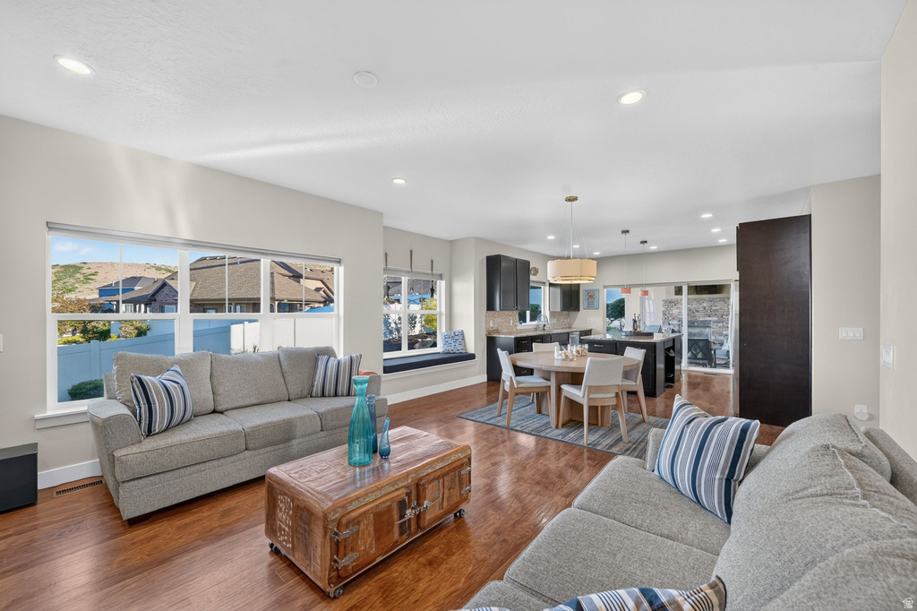Open-concept living area featuring wood-finish flooring, recessed lighting, and large windows