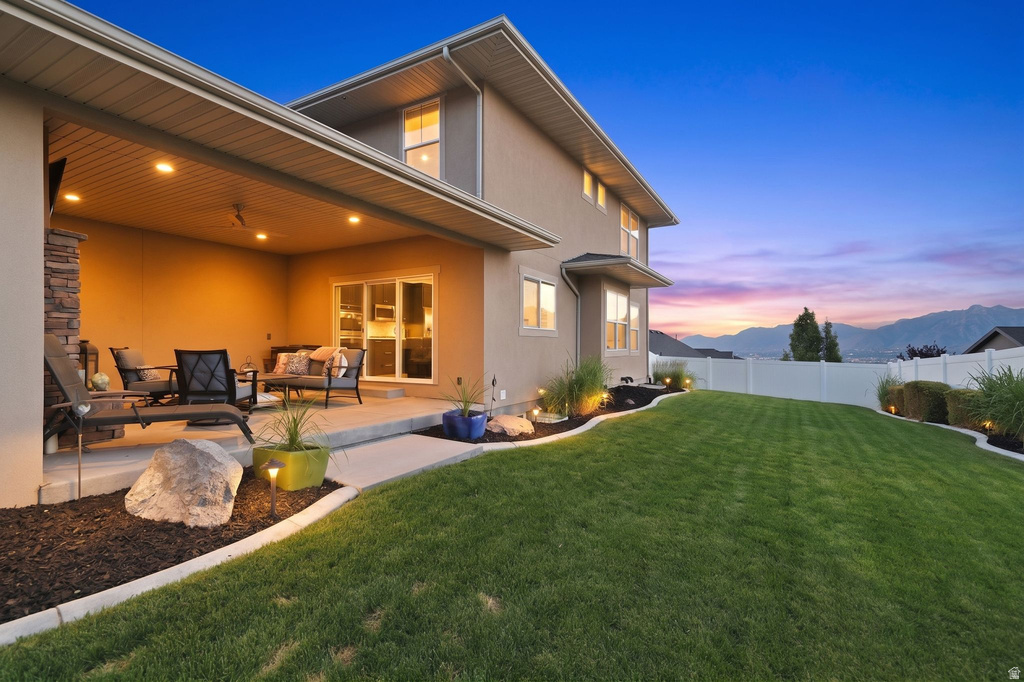 Expansive backyard featuring a covered patio with recessed lighting and a stone-clad pillar