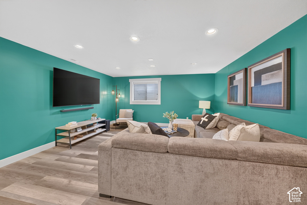Spacious room featuring wood-finish flooring, recessed lighting, and a white trim window