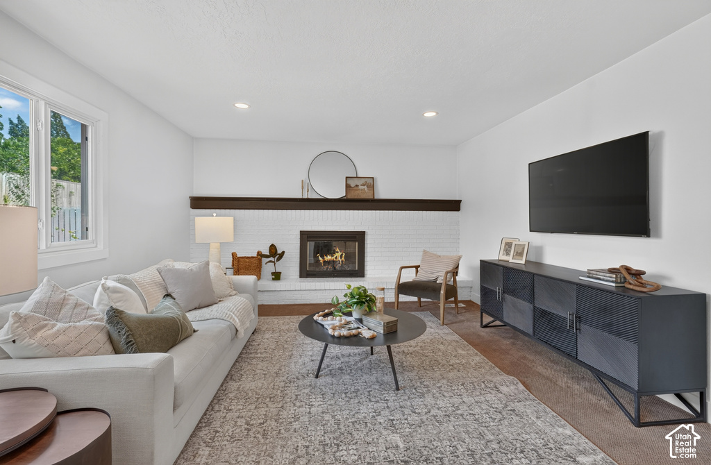 Living area featuring a white brick fireplace with a dark wood mantel