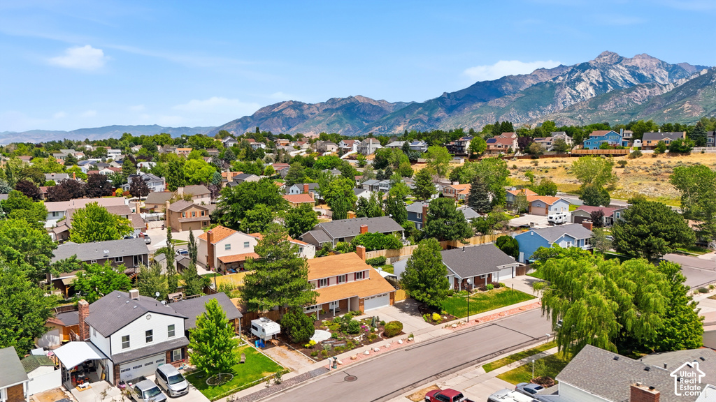 Residential area featuring a mix of architectural styles, mature trees, and mountainous scenery