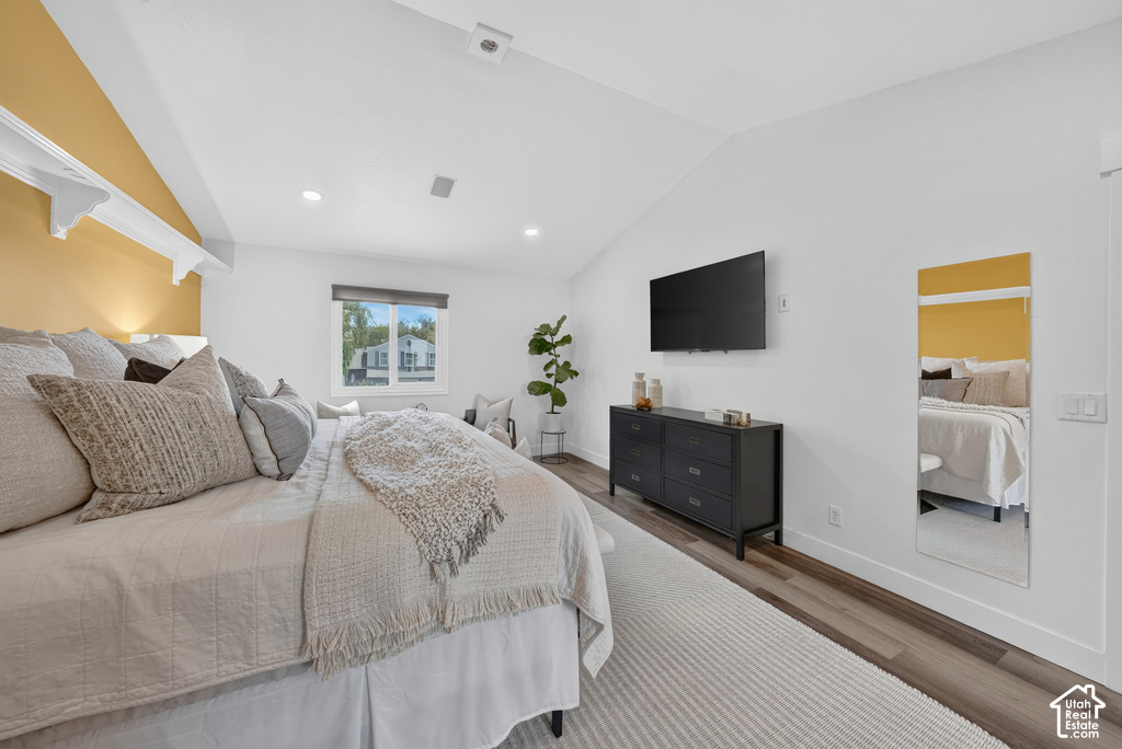 Vaulted ceilings featuring recessed lighting and wood-finish flooring