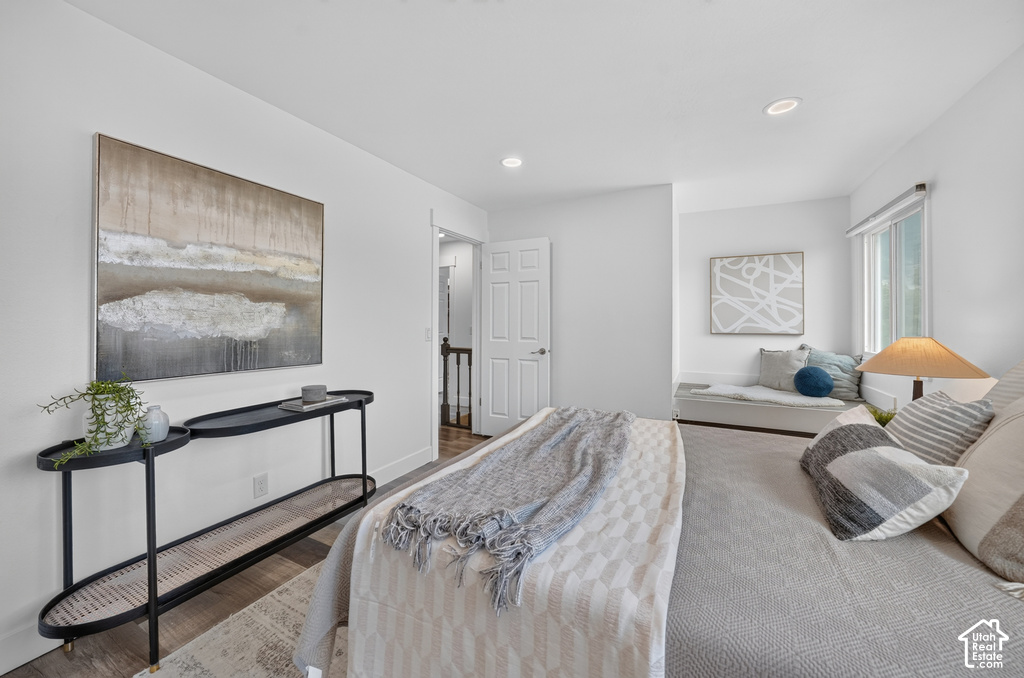 Neutral wall finishes with recessed lighting and wood-finish flooring
