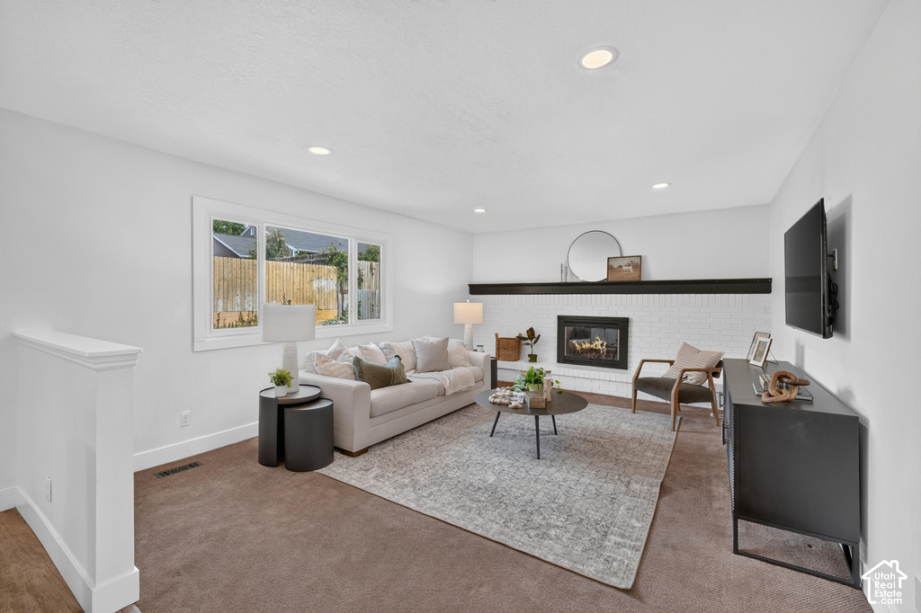 Living area featuring white walls, recessed lighting, and a broad window