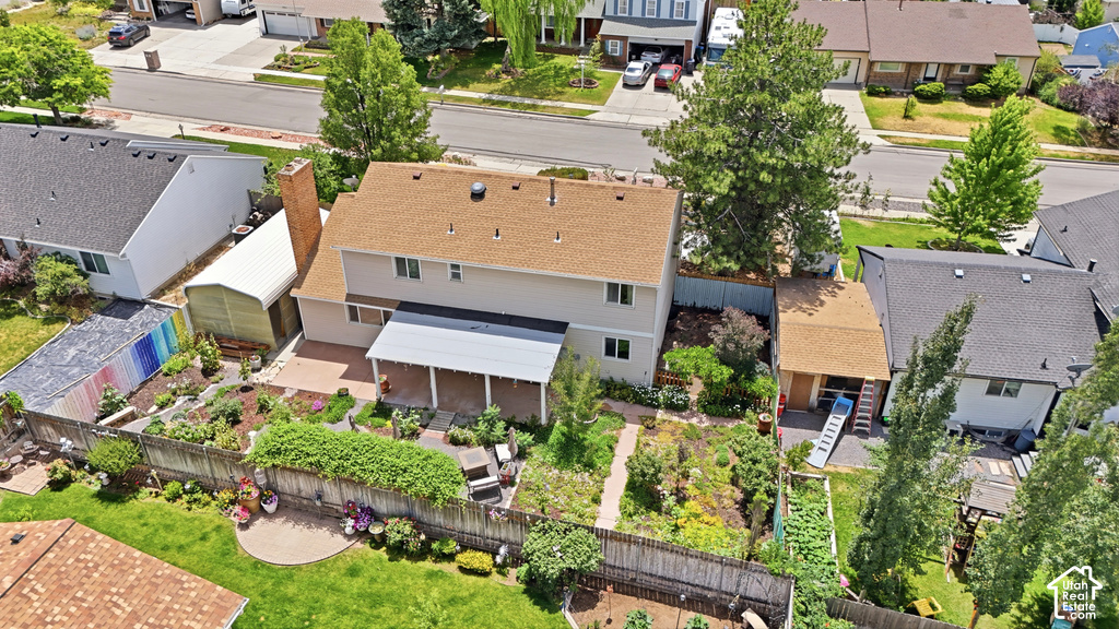 Two-story residence featuring a brown shingle roof, a rear covered patio, and a brick chimney