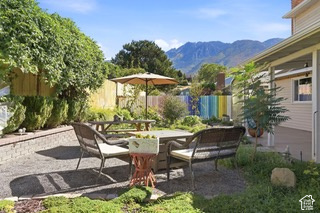 Expansive outdoor patio with a gravel surface, brick retaining wall, and mature landscaping