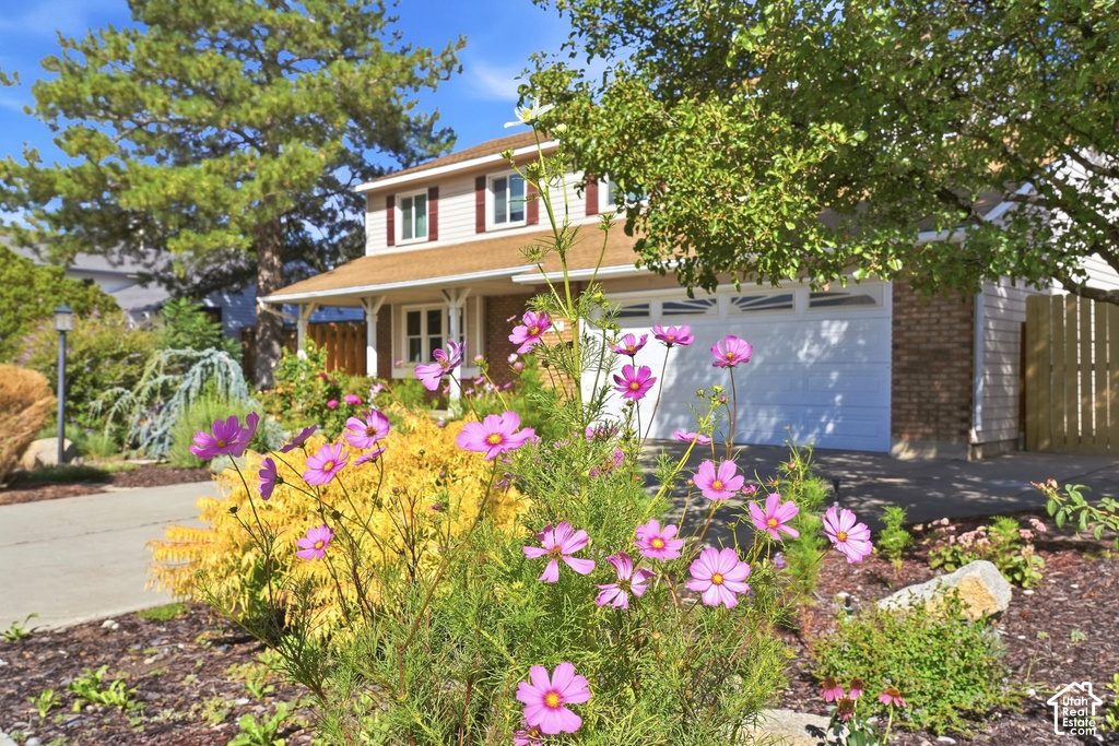 Two-story residence with a covered front porch, attached two-car garage, and a concrete driveway