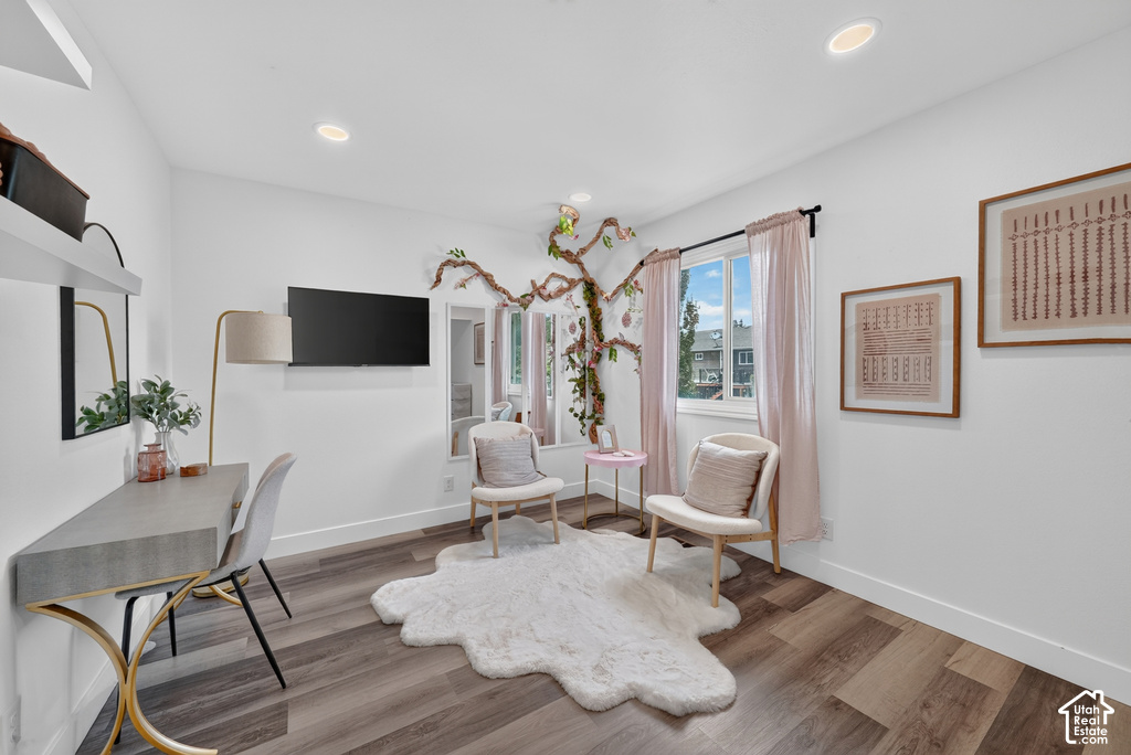 Room featuring wood-finish flooring, recessed lighting, and a window with a black curtain rod
