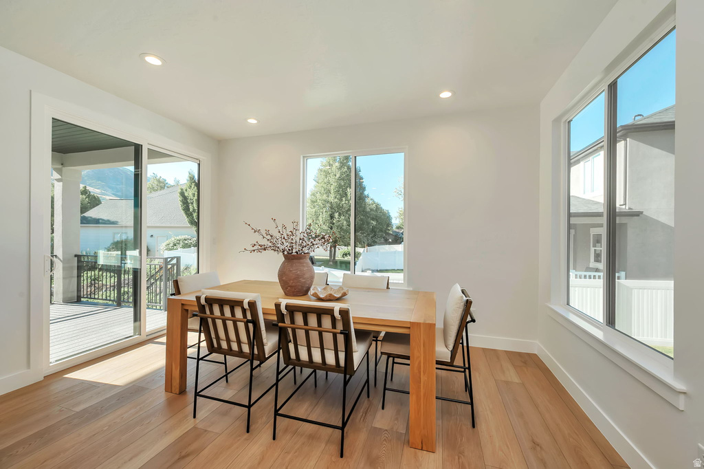 Bright dining area featuring hardwood-finish flooring, recessed lighting, and white walls