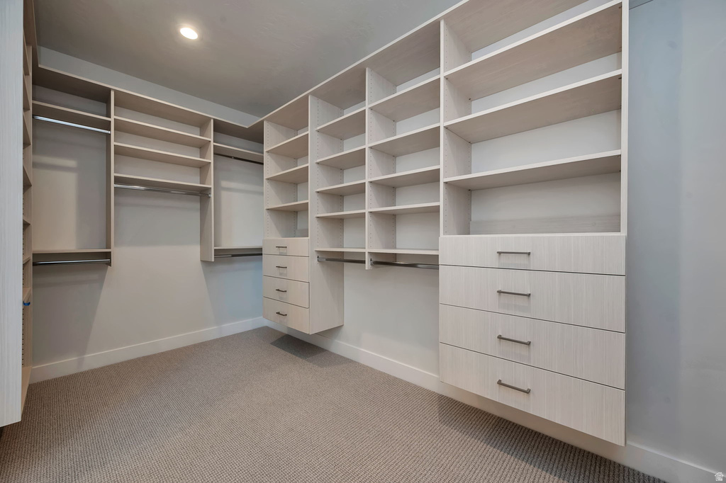 Custom closet organization system featuring light wood-finish cabinetry