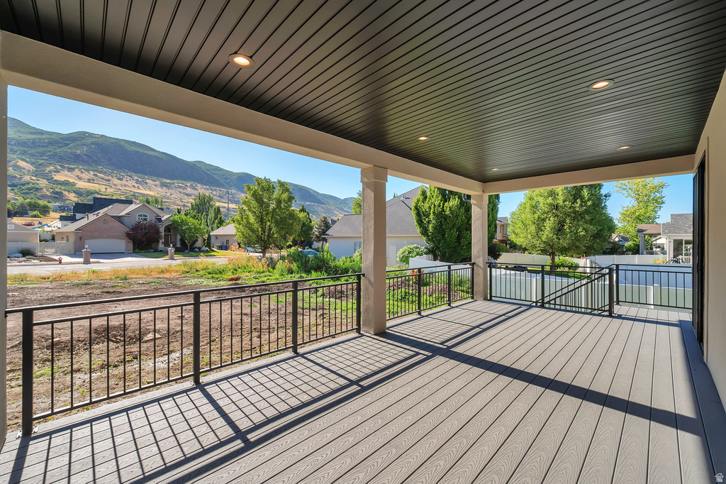 Covered outdoor deck featuring composite decking, recessed lighting, and black metal railings