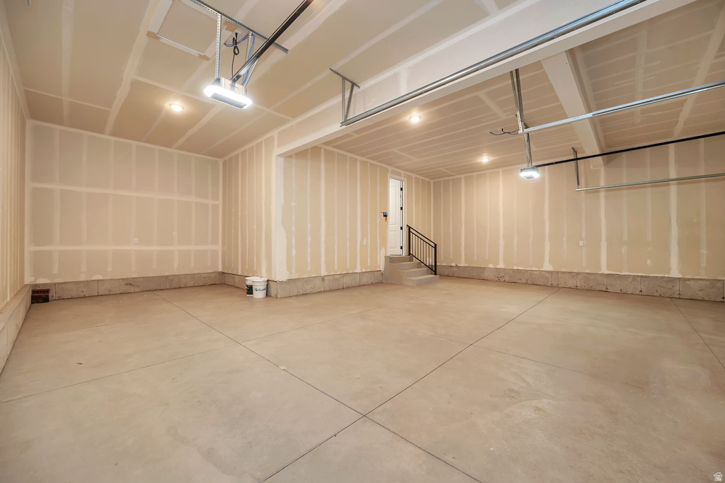Spacious two-car garage featuring a concrete floor, high ceilings, and recessed lighting