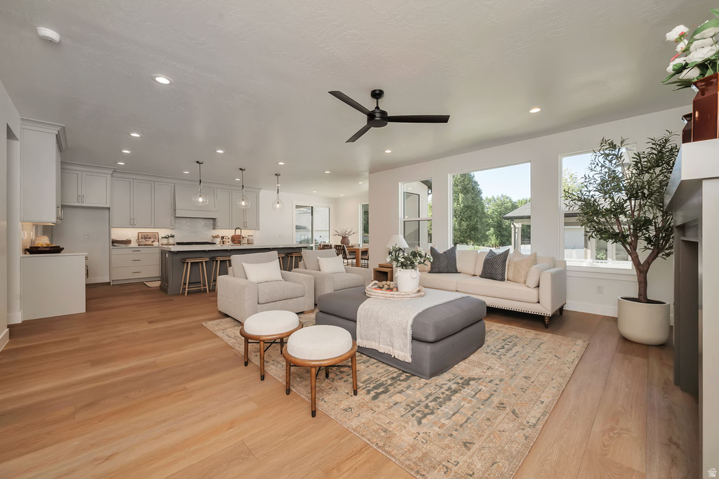 Open-concept living space featuring wood-finish flooring, recessed lighting, and a contemporary ceiling fan