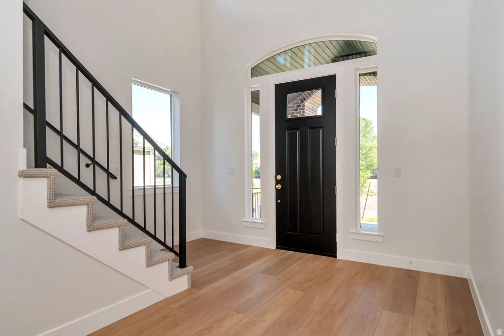Double-height entryway featuring a dark wood-paneled door with an arched transom window and sidelight windows
