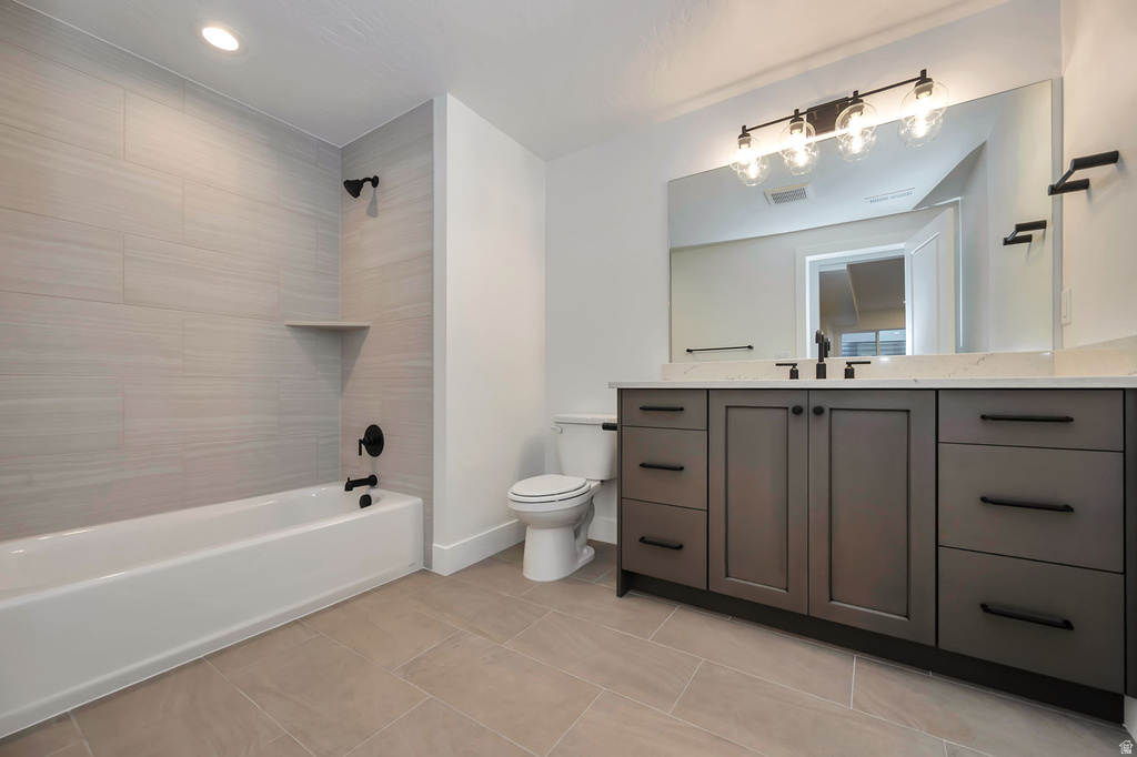 Full bathroom featuring a white soaking tub with a tiled surround, a large vanity with a light-colored countertop, and matte black fixtures