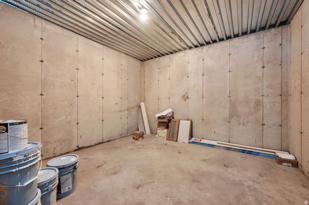 Concrete-walled room with metal-paneled ceiling and concrete flooring