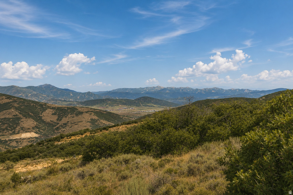 Expansive mountainous terrain featuring varying elevations, natural vegetation, and distant valley