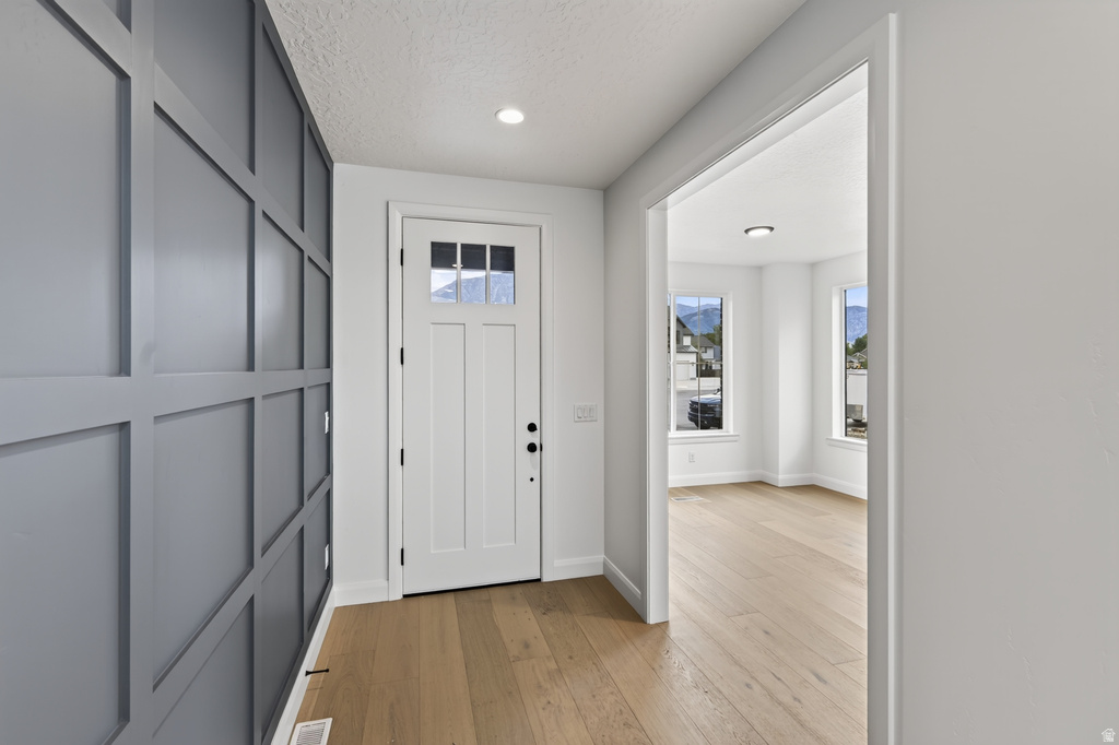 Entryway featuring modern wainscoting, recessed lighting, and light wood-finish flooring
