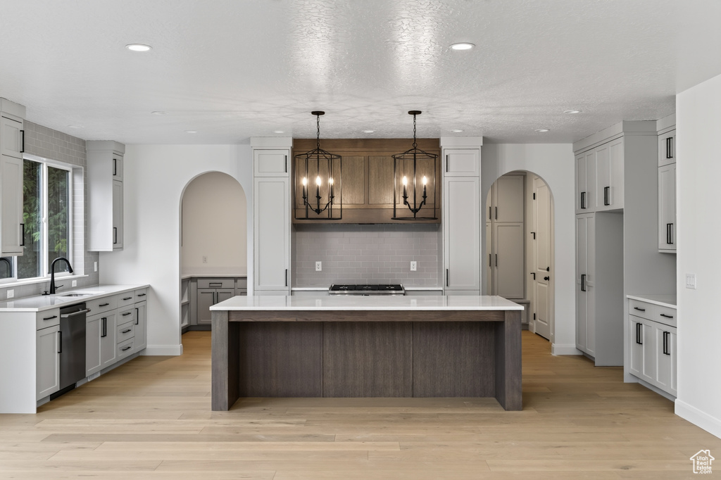 Open-concept kitchen featuring an oversized island with a white countertop