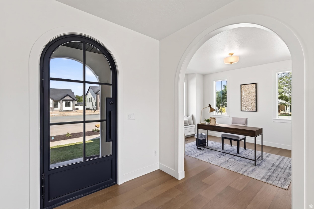 Arched entryway featuring a full-light door with dark framing and sidelight