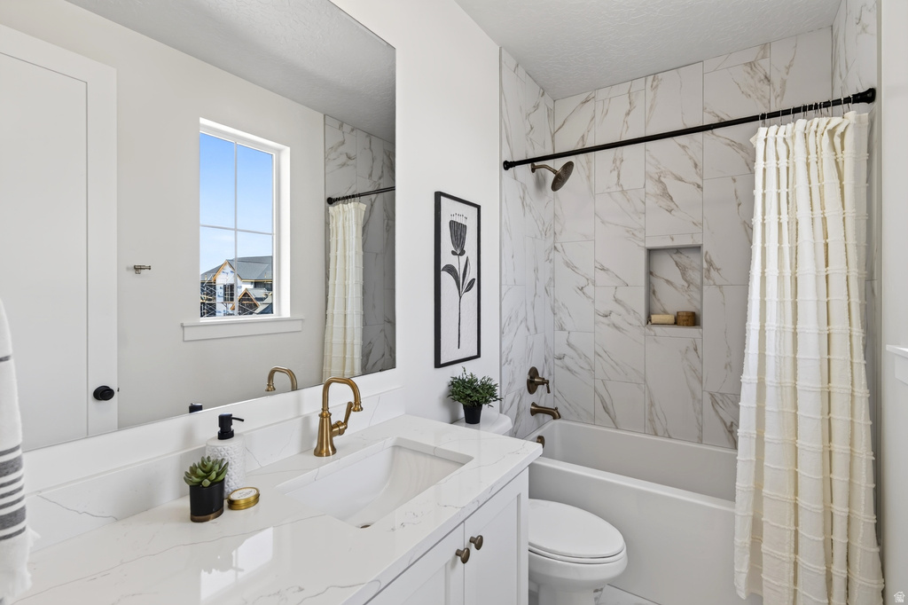 Bathroom featuring a white vanity with a rectangular undermount sink, brass-finish faucet, and a quartz countertop