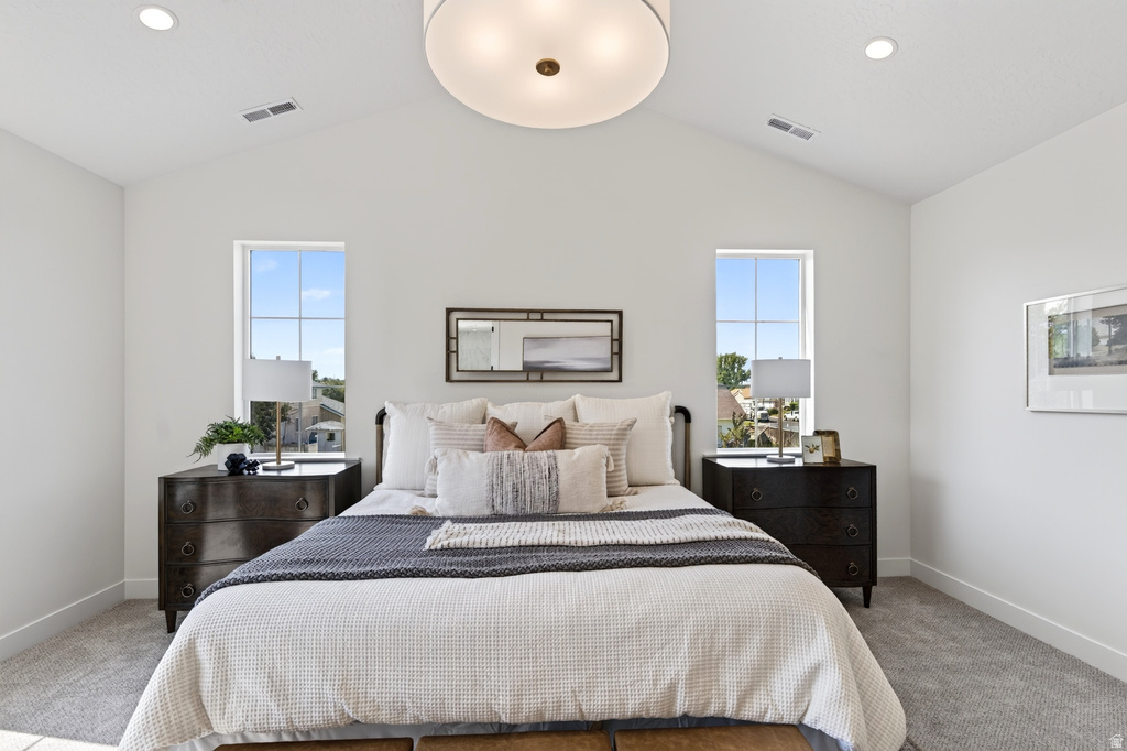 Vaulted ceiling bedroom featuring two tall windows, recessed lighting, and a drum pendant light fixture