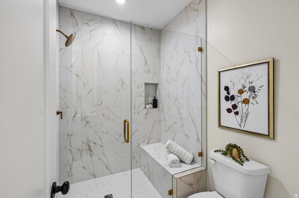Walk-in shower featuring a frameless glass enclosure, a built-in bench, and a recessed niche