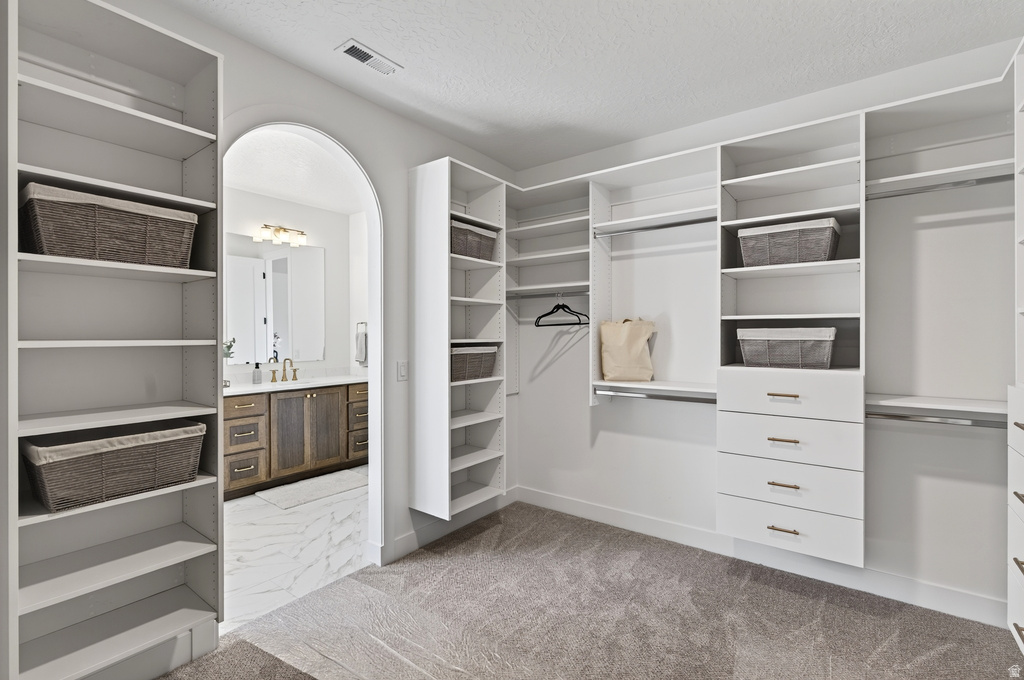 Customizable closet system with multiple shelving units, hanging rods, and integrated drawer storage