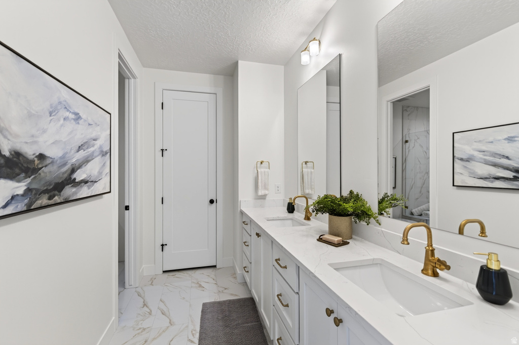 Dual vanity with integrated rectangular sinks, accented by gold-finish faucets and hardware